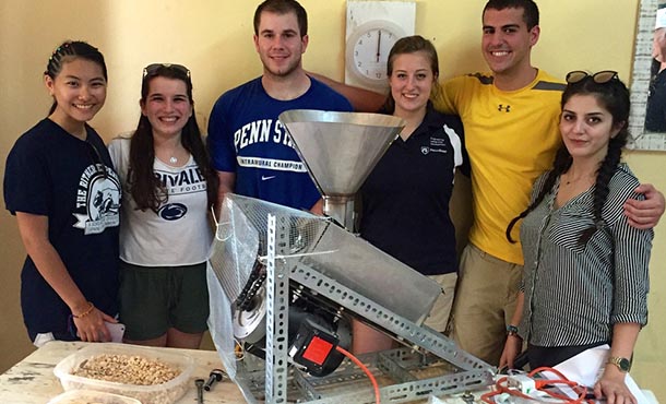 Students stand with the baobab-processing machine.